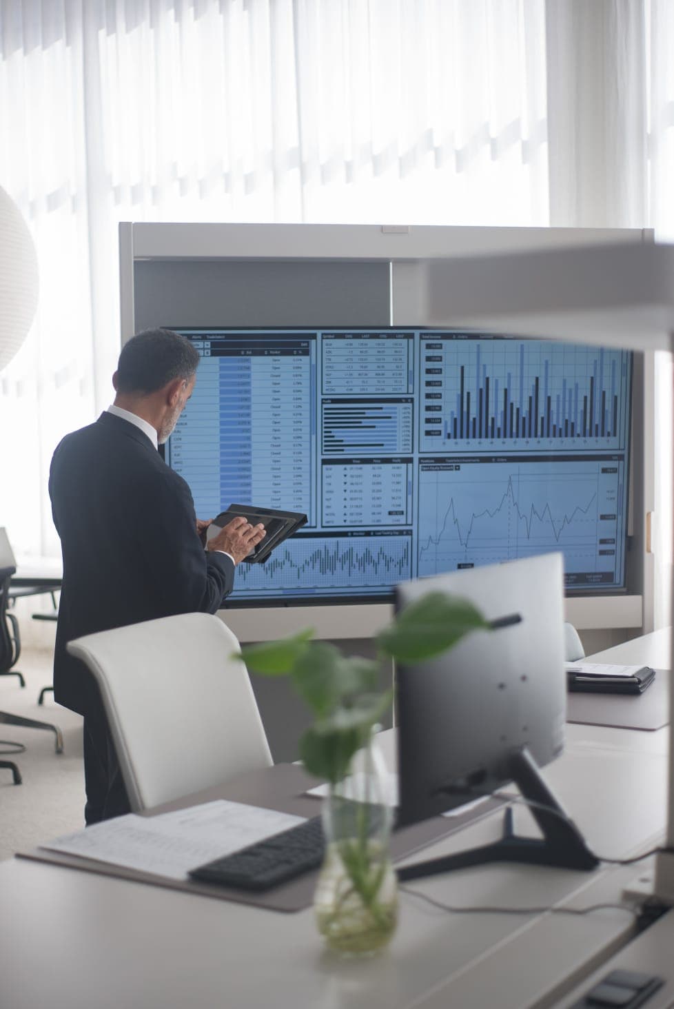 Gestor analisando painéis de indicadores do ERP em uma tela grande